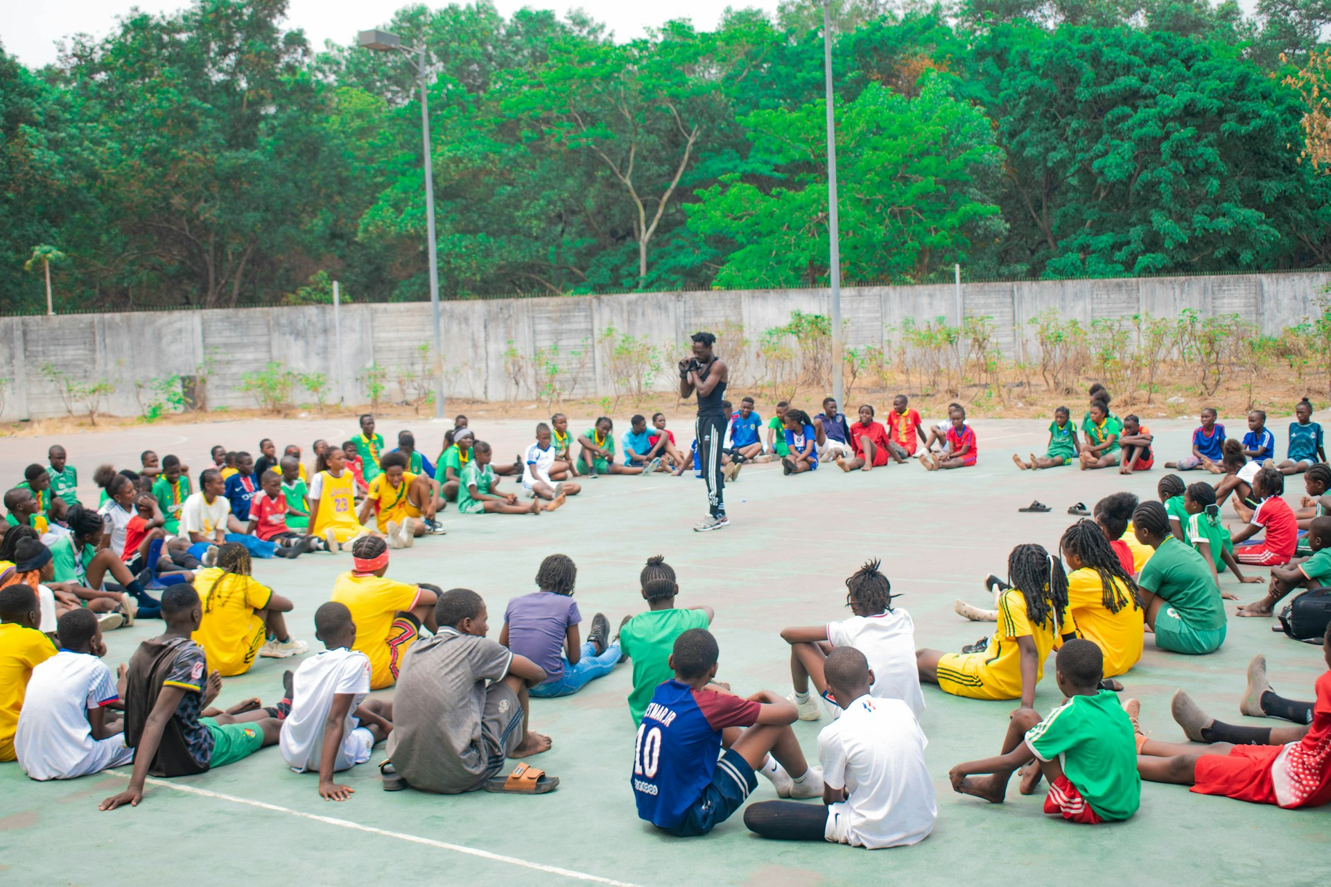 Man addresses group of people sitting in a circle.